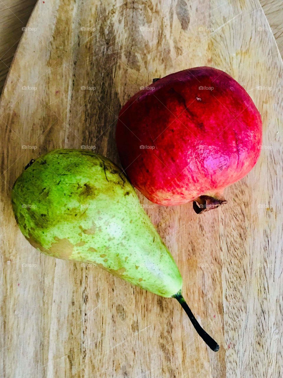 Pear and pomegranate on a wooden background.