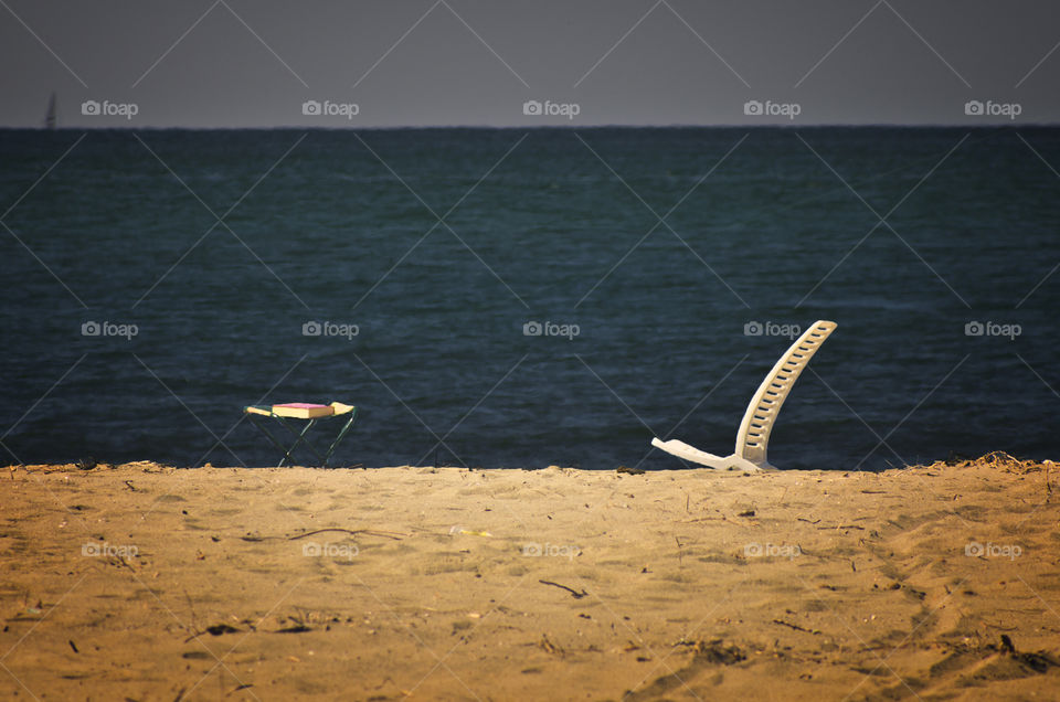 a chair and books on the beach