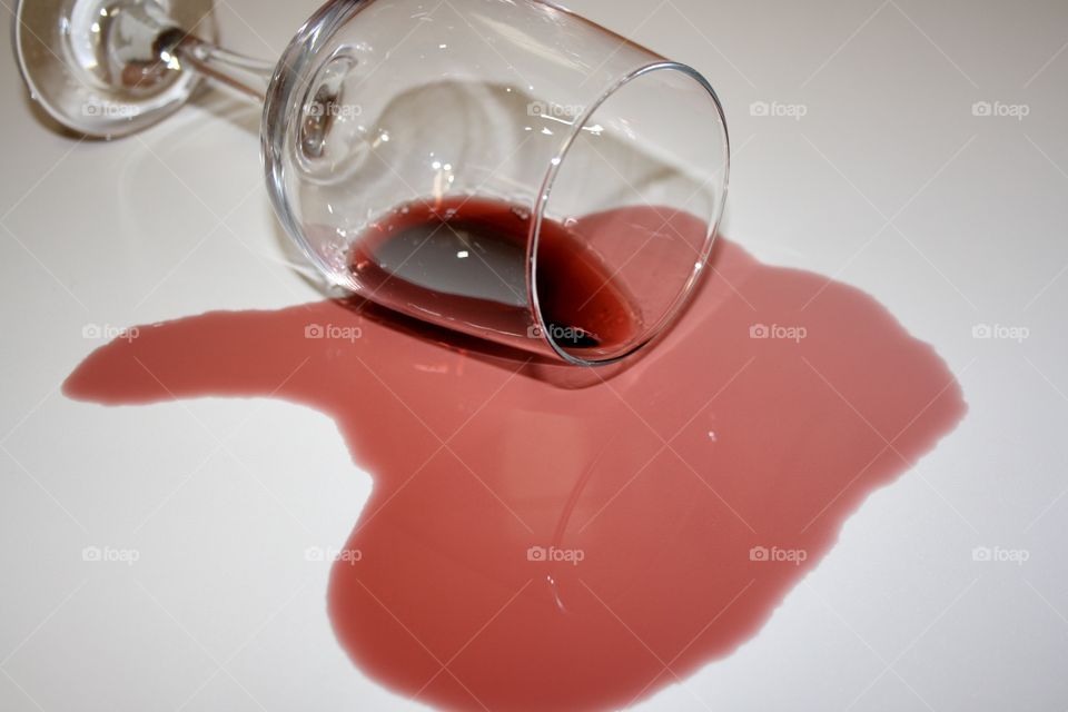 A glass of wine. Two shades of red can be seen. The wine from the glass is dark red and the poured wine is light red.