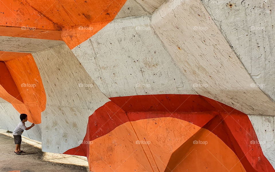 a boy playing under rock climbing