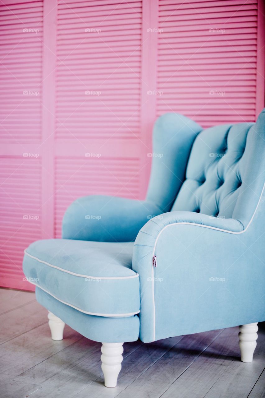 soft blue armchair on a pink background