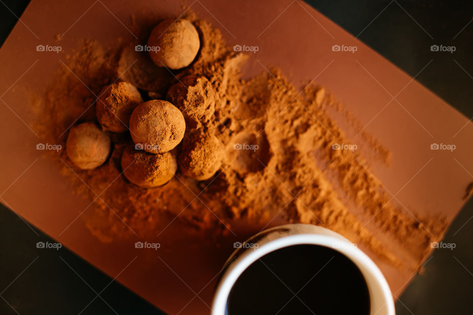 Chocolate balls and cup of coffee on dark background