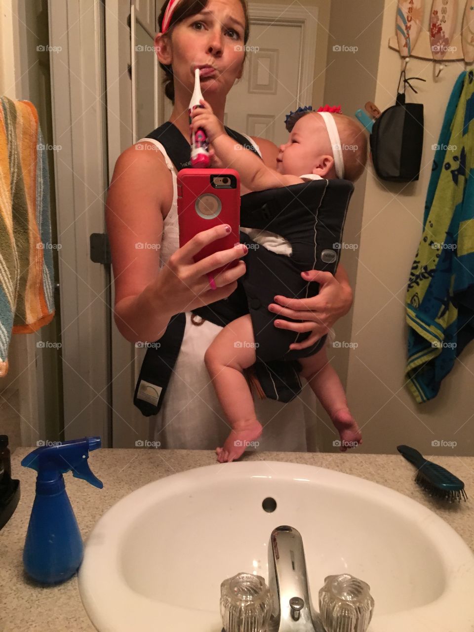 Reflection of a mother taking selfie with her daughter in mirror