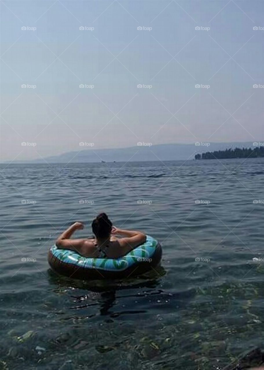 woman relaxing in float tube on lake