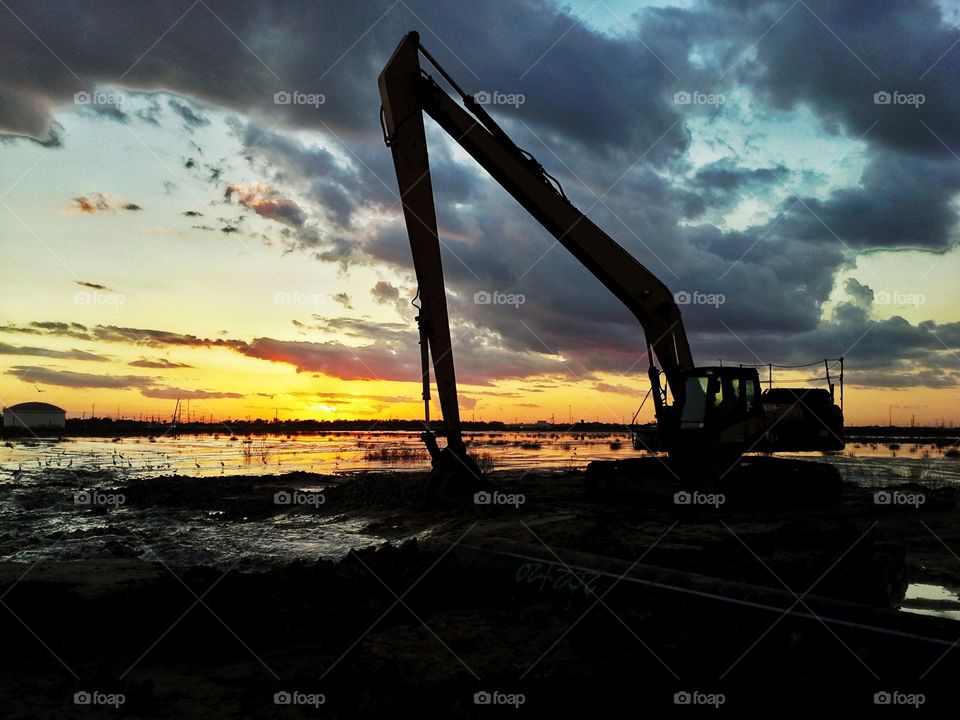 Long reach excavators at sunset