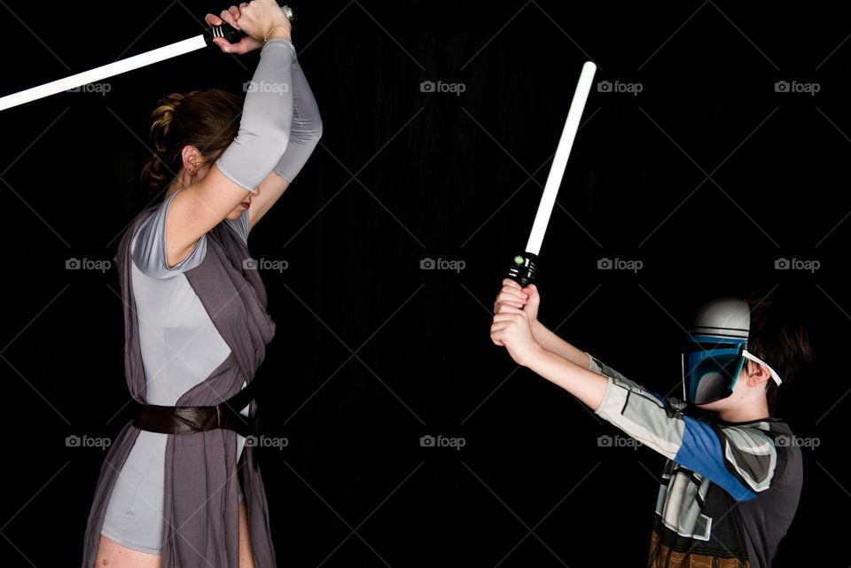 Mother and son larping dressed in costume as Star Wars themed characters with light sabers