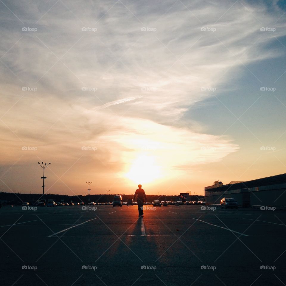 Man crossing road in the sunset