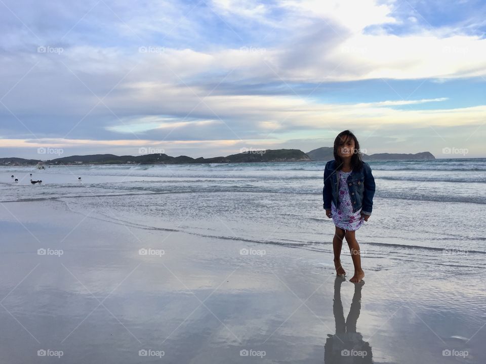 little girl on the seashore, sunset