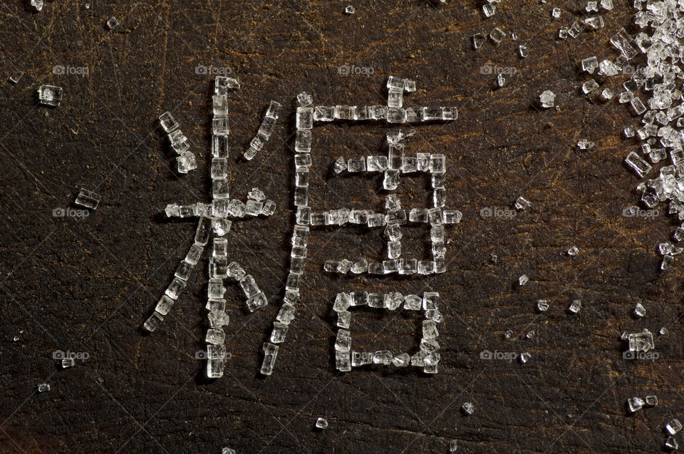 Word Sugar written in Chinese characters using Sugar crystals, close up