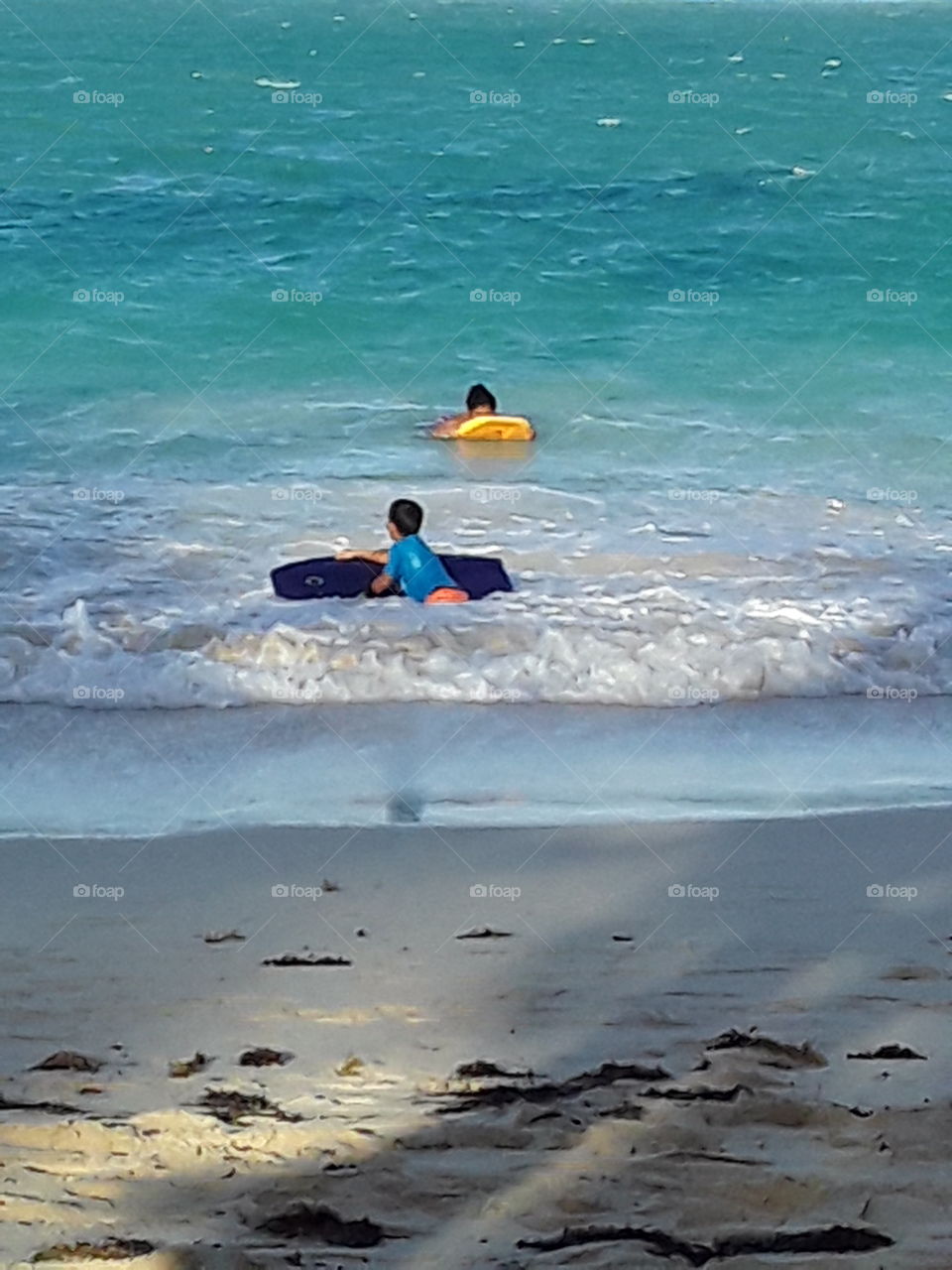 people swim on plastic boards in the ocean
