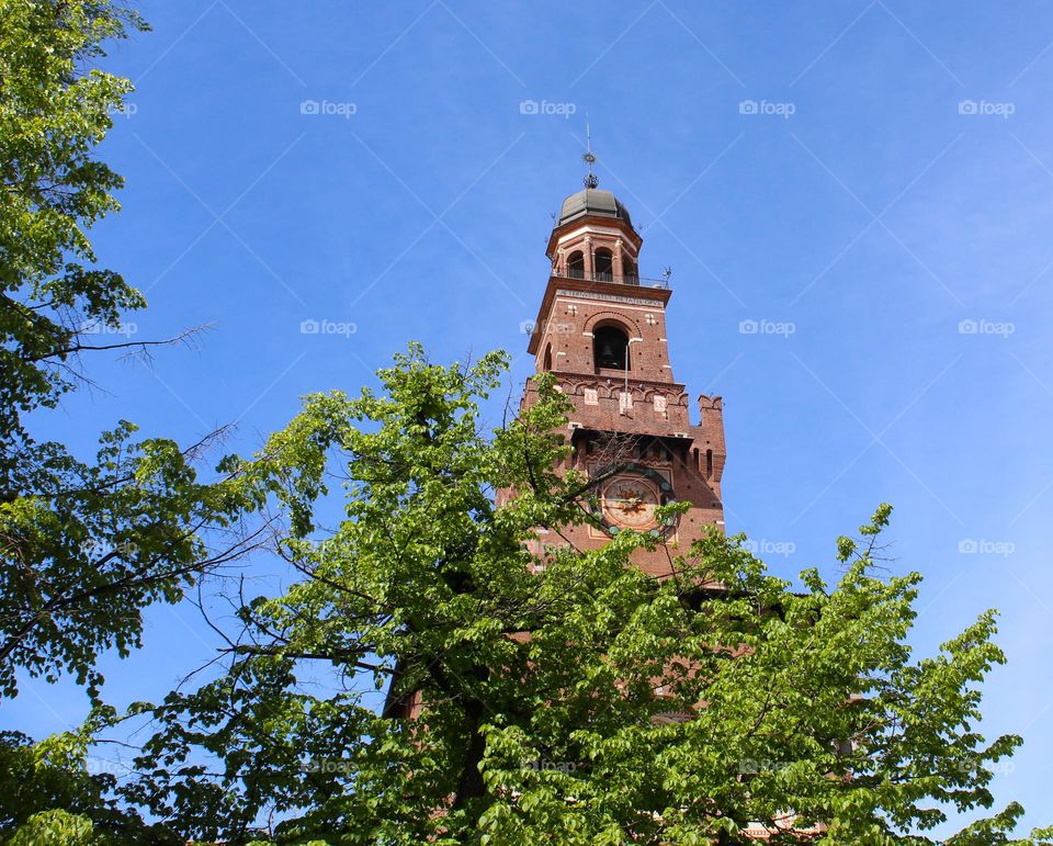 The old tower of the fairytale castle of Sforza surrounded by wonderful spring greenery.  Milano,  Italy