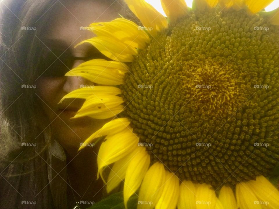 Selfie with giant sunflower covers much of face