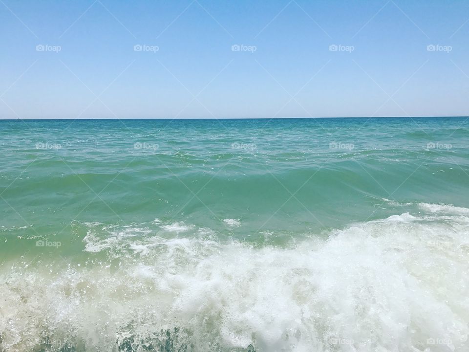 Small surf splash on blue green ocean. 