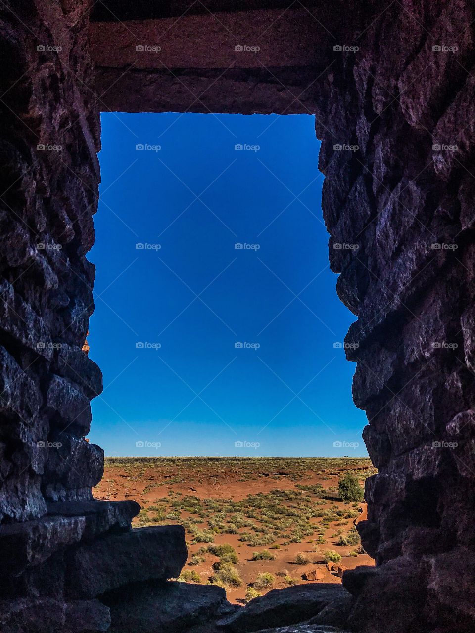 View of Arizona desert through a rectangular window of a Pueblo ruin