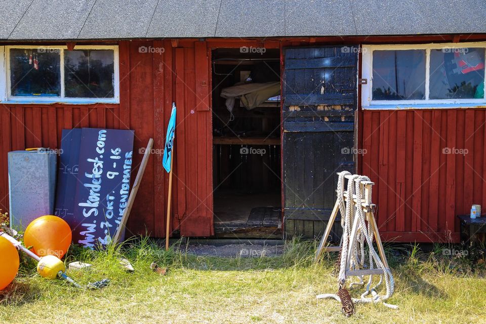 Fishing village. Red fishing house with open door on a summerday