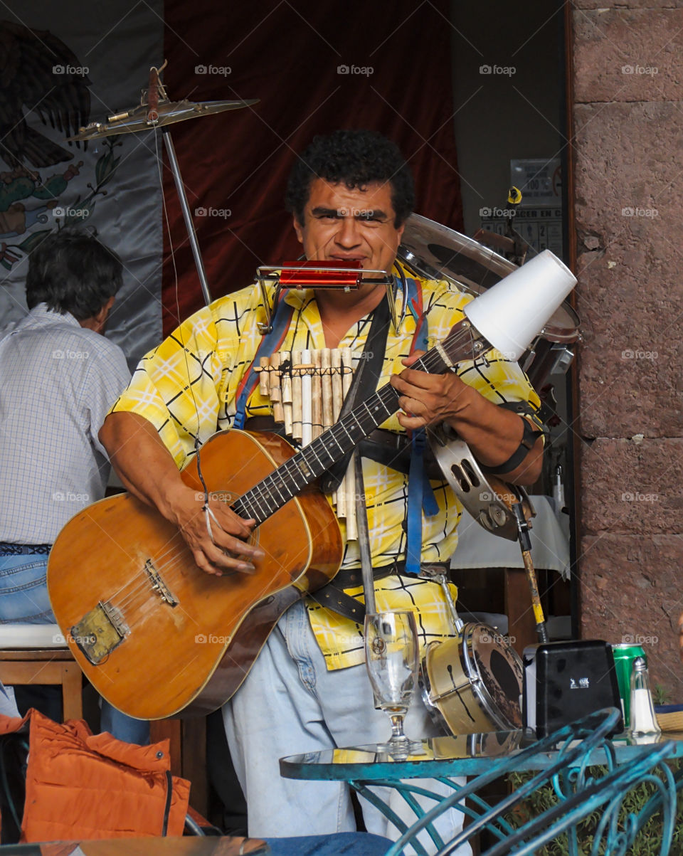 One man band performing outside of a street cafe in San Miguel de Allende, Guanajuato, Mexico