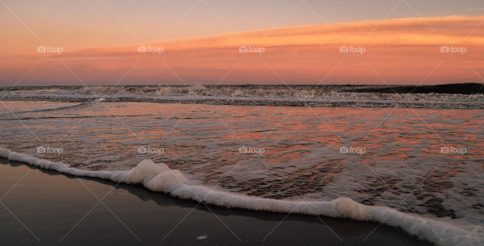 Sunset Seascape golden hour in the beach orange and pink sky, sea water brown sand landscape outdoor nature background