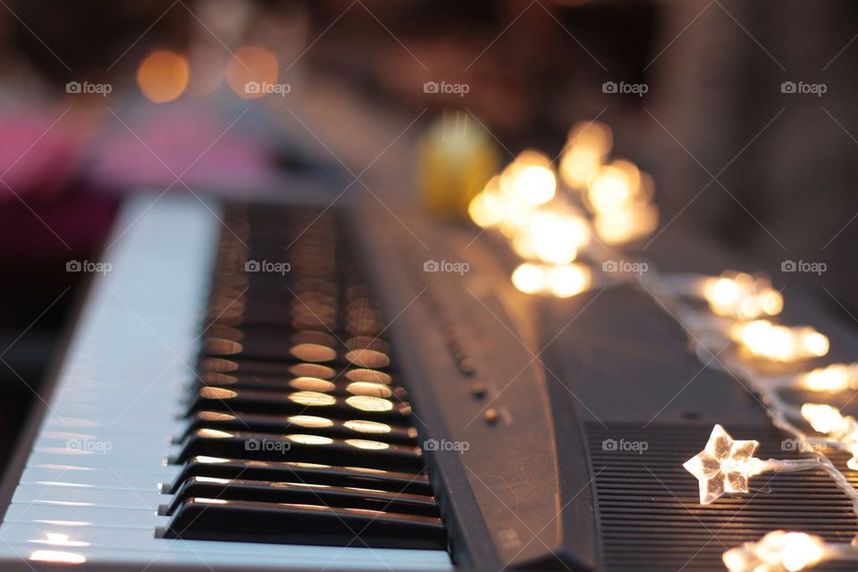 Close-up of piano keyboard with christmas lights