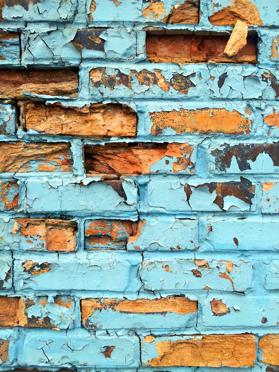 Brick wall with lite blue chipped paint