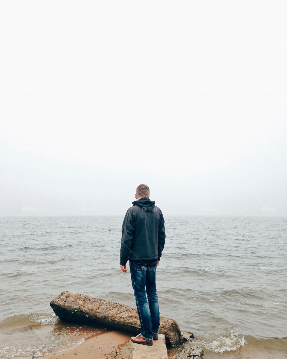 Rear view of a man in front of sea