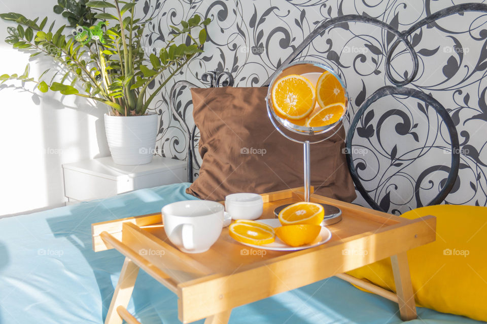 A man at home takes care of himself and does a manicure at home on a blue background and with orange.
