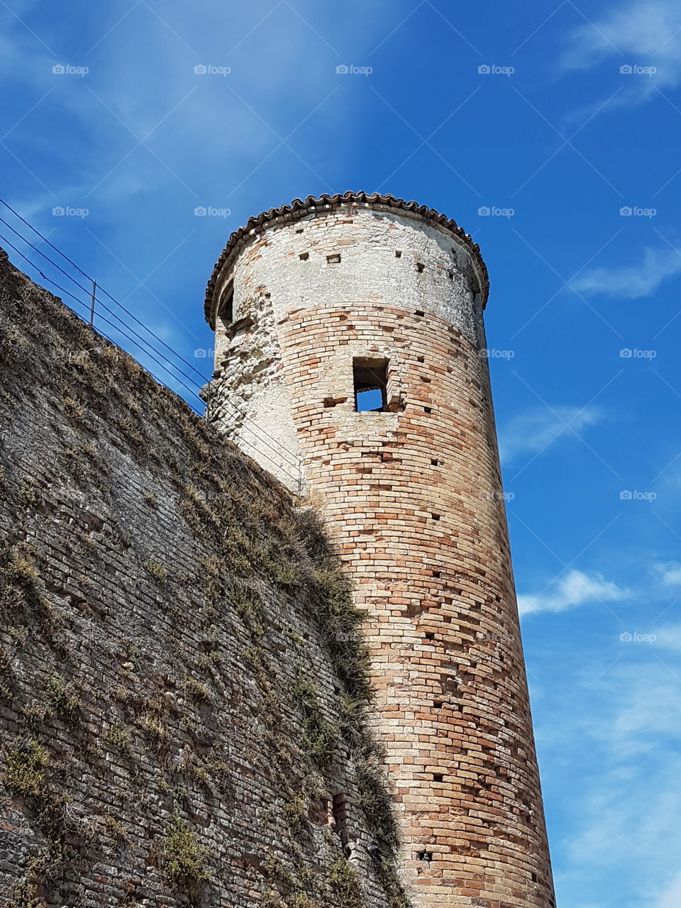 Tower of a medieval italian castle with blue sky