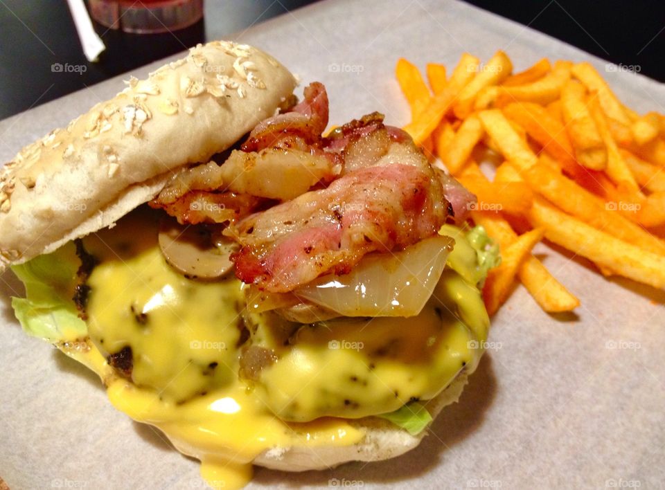 Cheesy burger with bacon and caramelized onions and fries