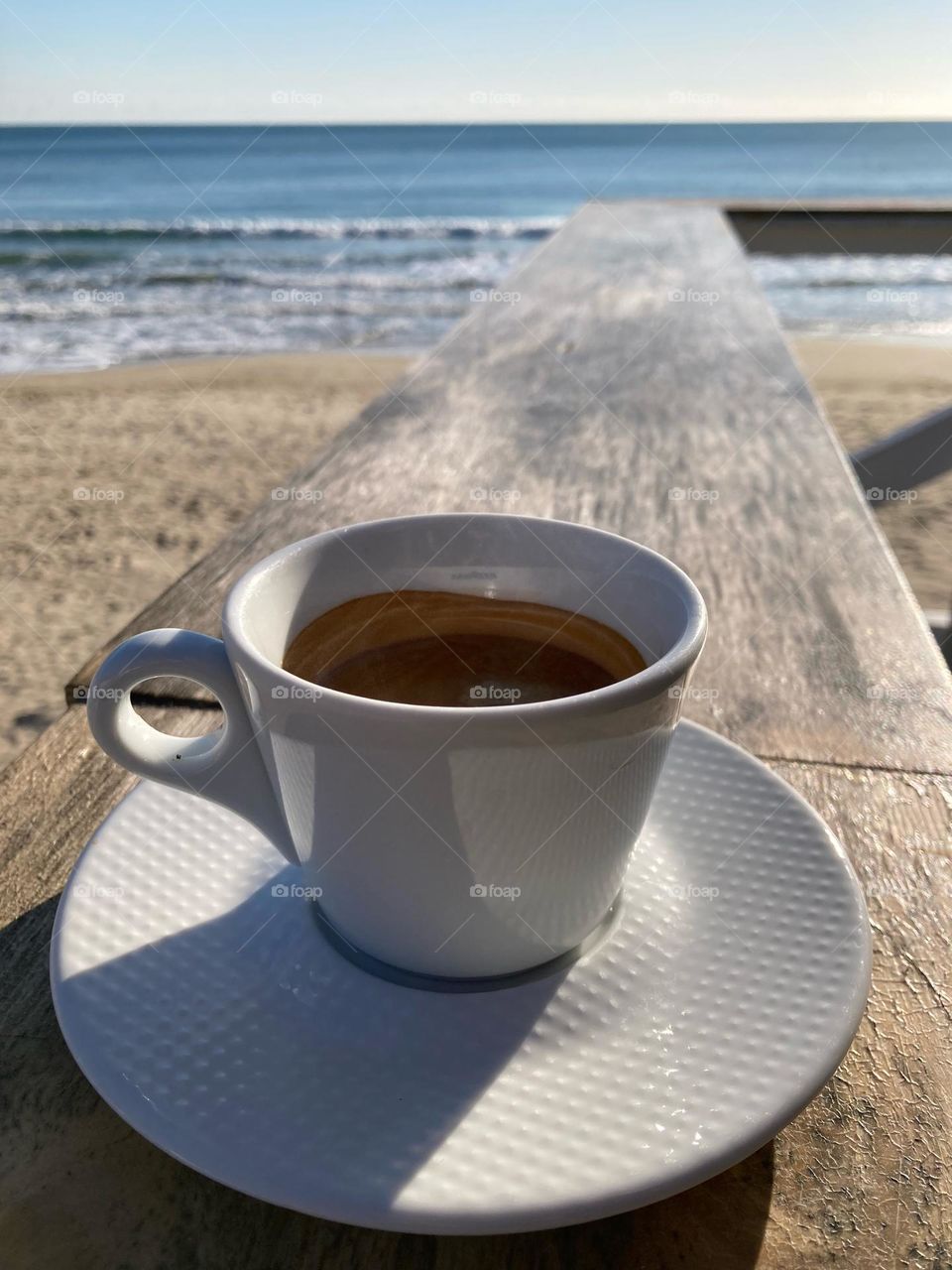 Coffee in a white porcelain cup by the seaside 