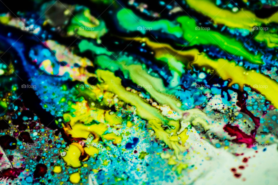 The ink to refill the printer cartridge was spilled onto the white washbasin and the paints blended into abstract drips and patterns.