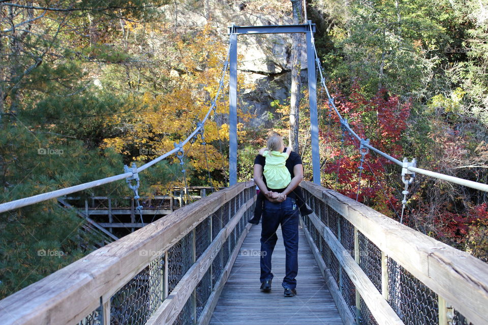 Dad holding daughter at the bridge