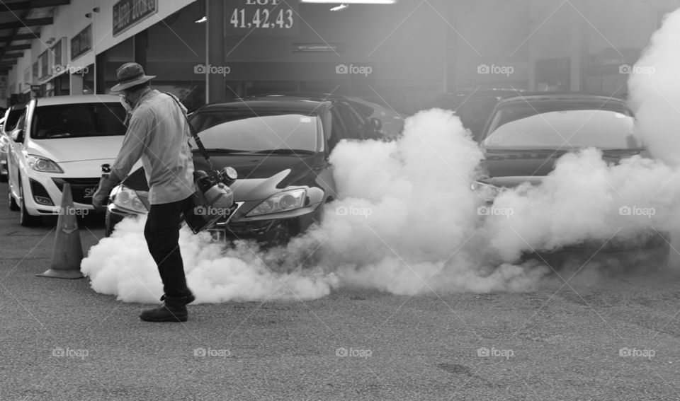 Man applying pesticide in a garage