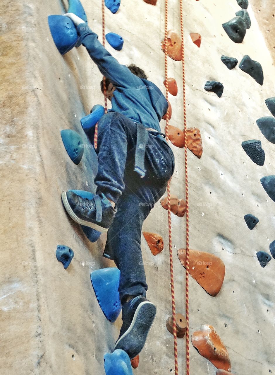 Boy Climbing A Rock Wall
