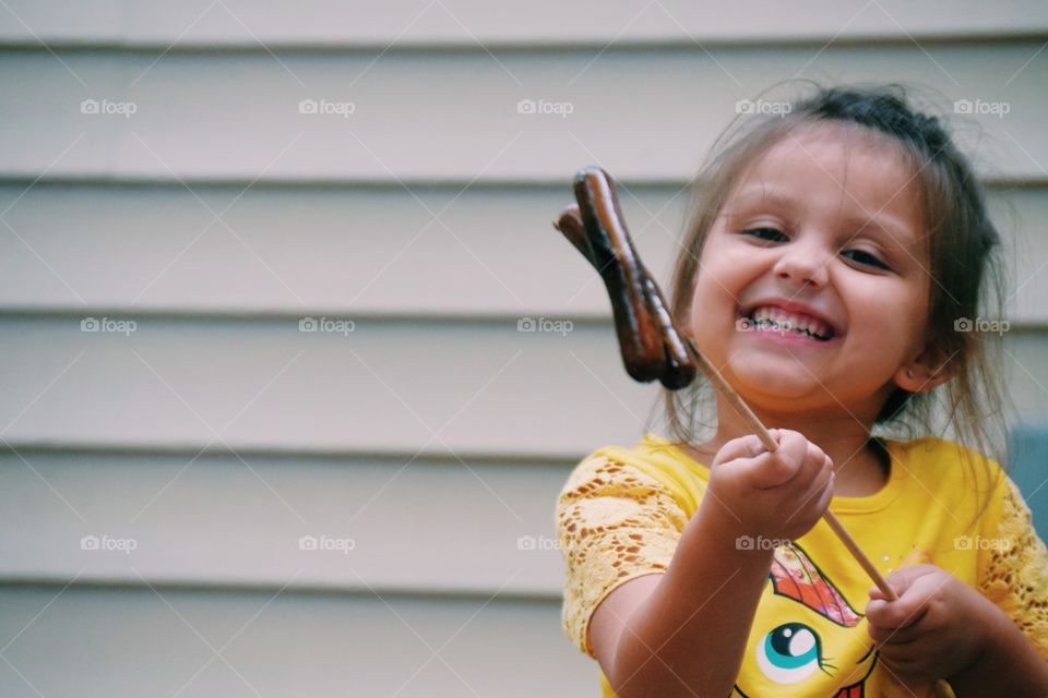 Small girl holding sausages in hand