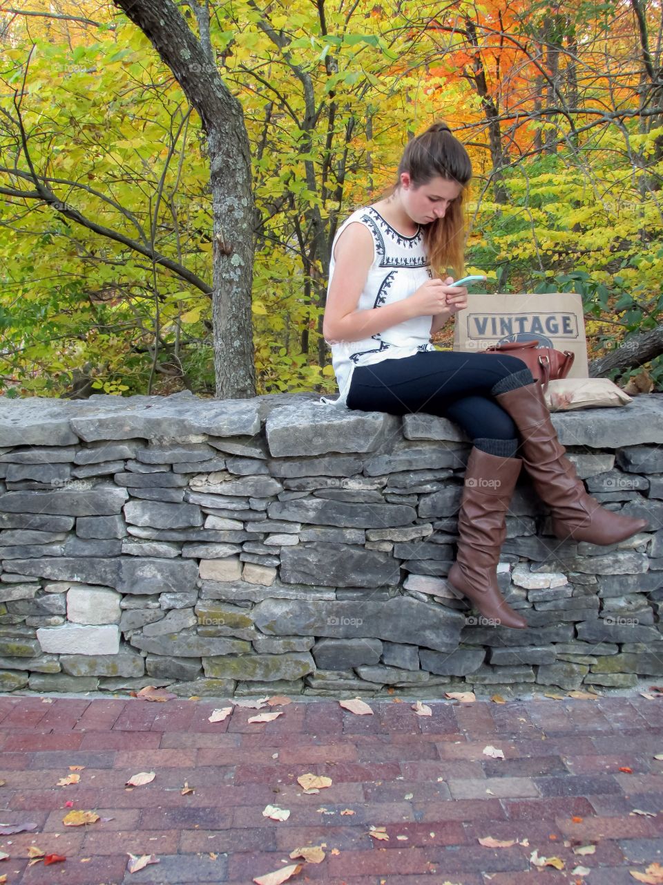 Young woman sitting on rocky wall