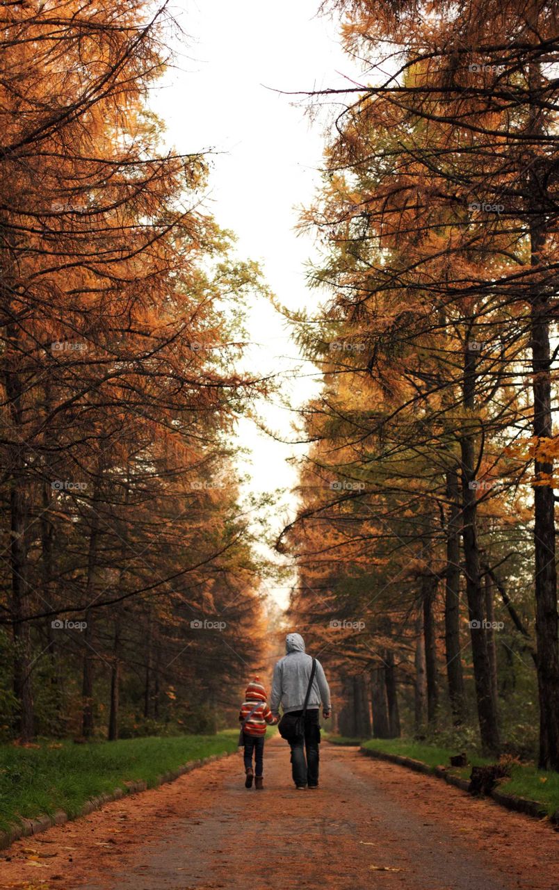 Daughter and dad walk in the botanical garden in autumn