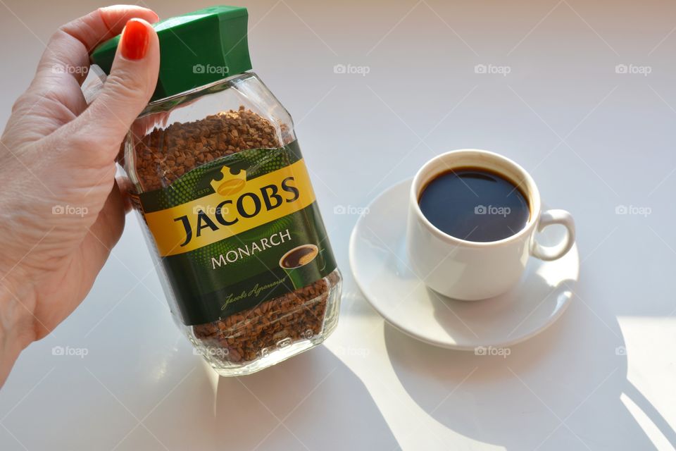 coffee Jacobs in female hand and mug white background