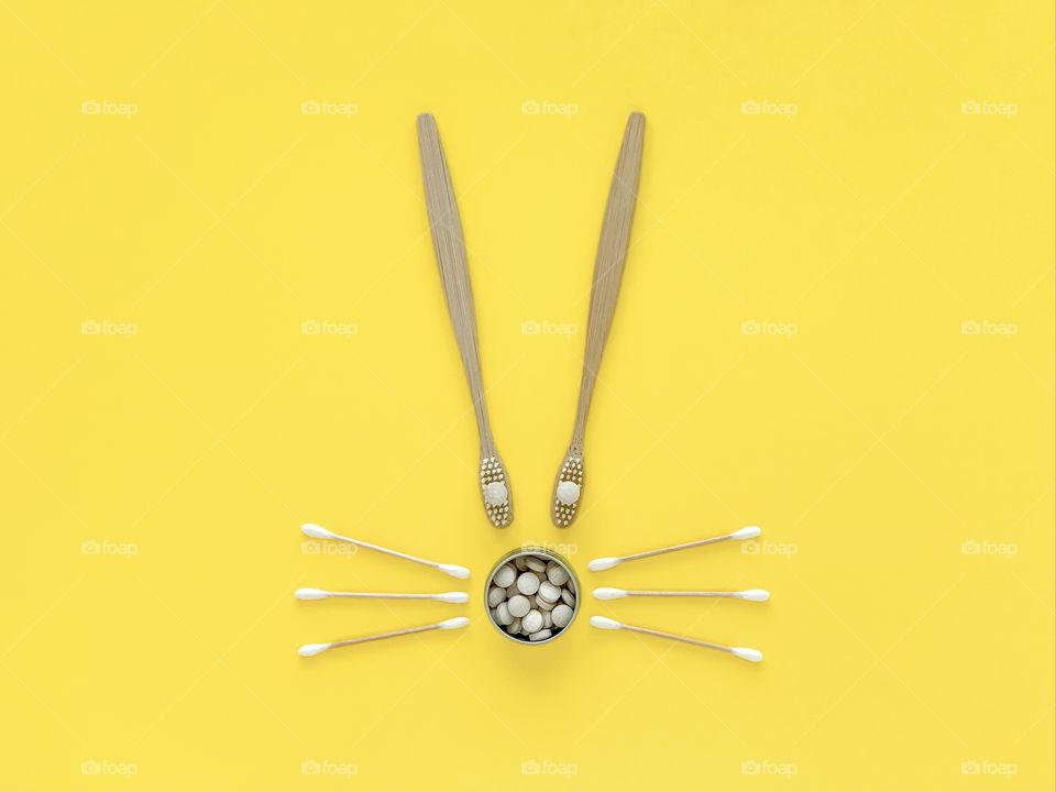Easter bunny, eco goods: bamboo toothbrushes, toothpaste, natural ear sticks. Illuminating yellow.