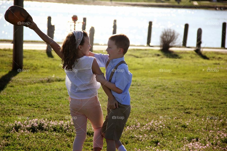 Playing around . Brother and sister enjoying spring weather at the lake