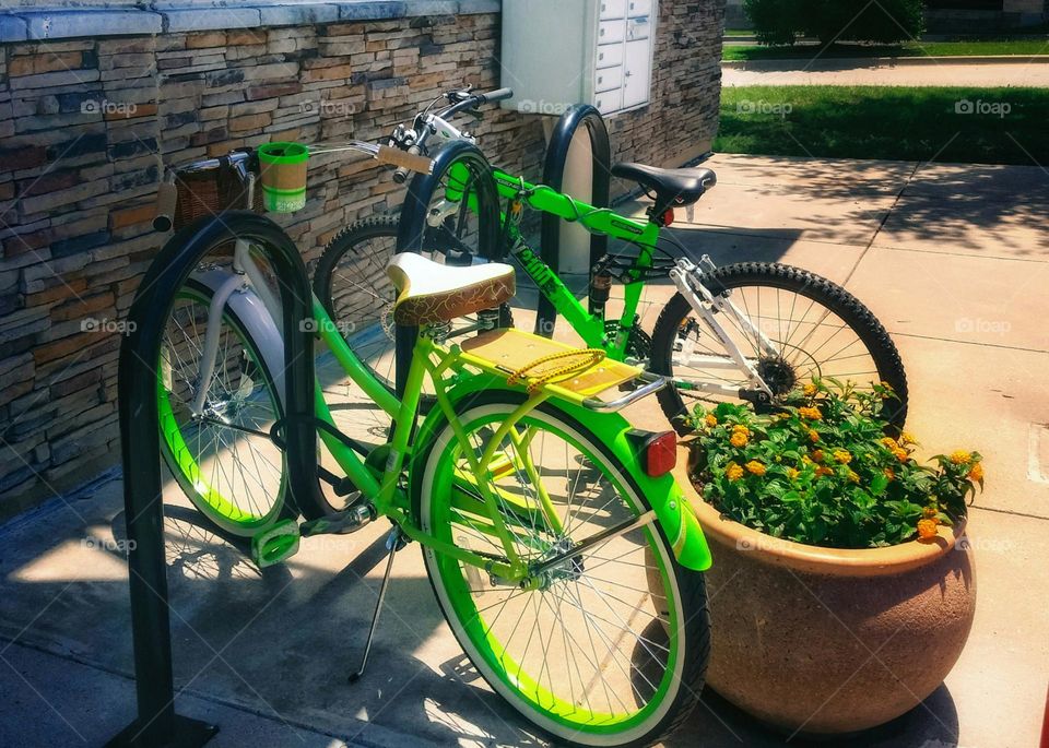 Two Green Bicycles in an Urban Setting