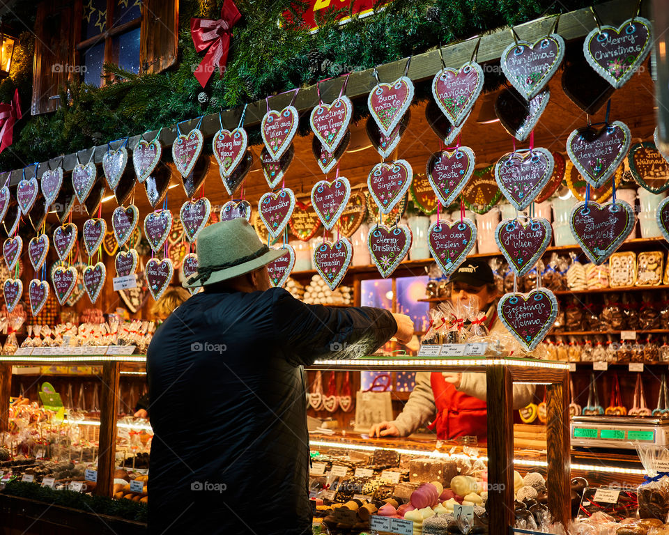 A man shopping at traditional Christmas market in Austria. Gingerbread Hearts at the Christmas Market. 