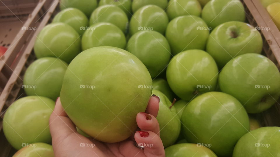 Granny smith green apple in person's hand