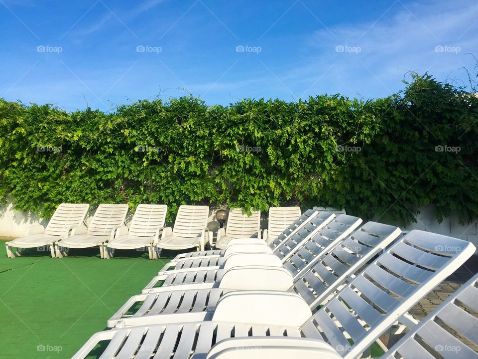 White empty lounge chairs on garden