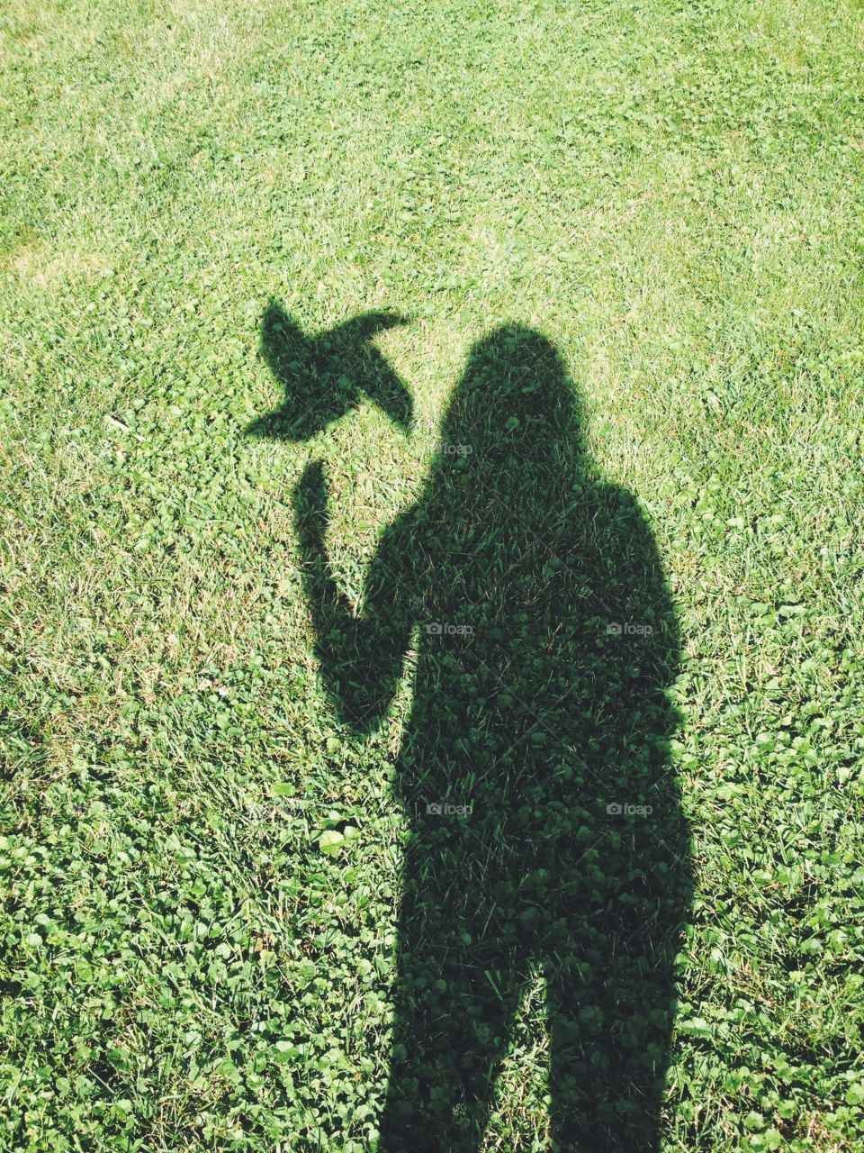 Shadow of a person holding pin wheel