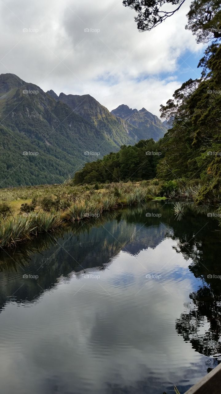 Clouds and mountain range reflected on lake