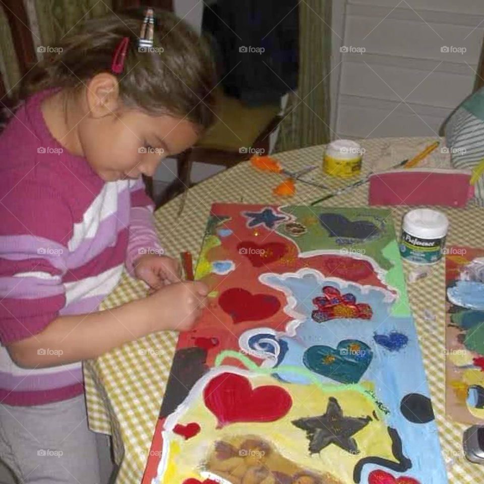 la niña pintando con interés