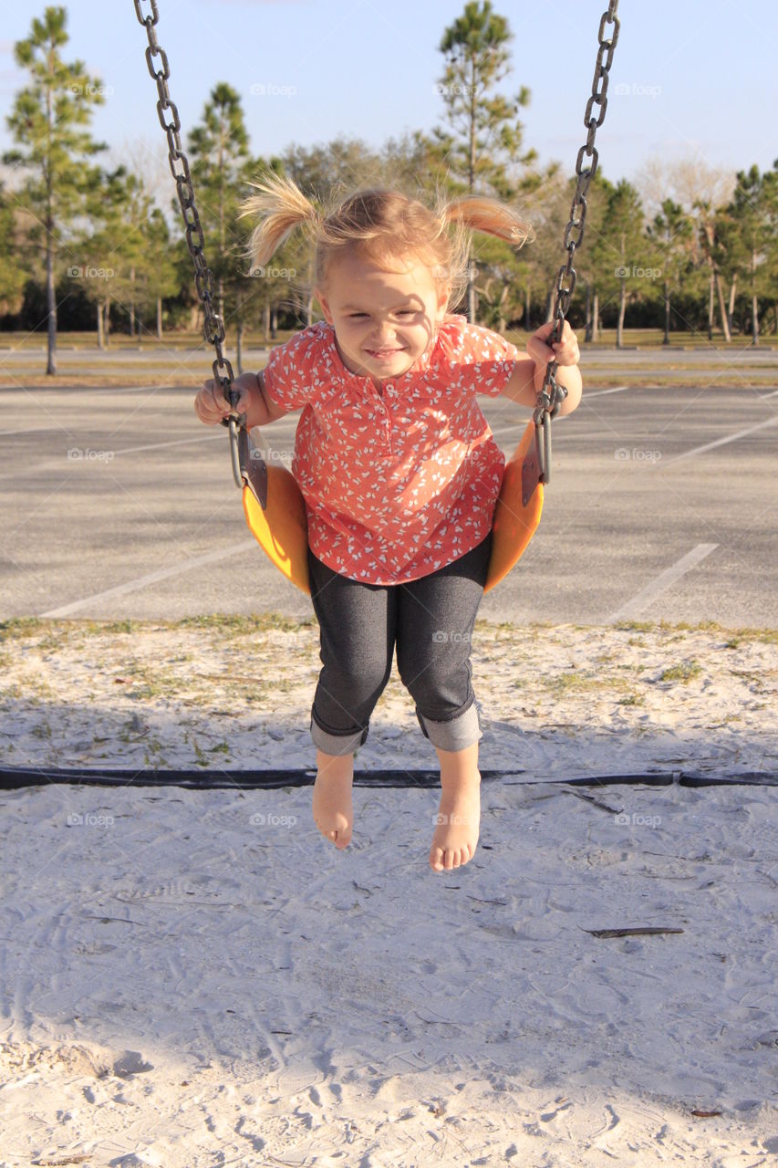 Cute girl playing on swing