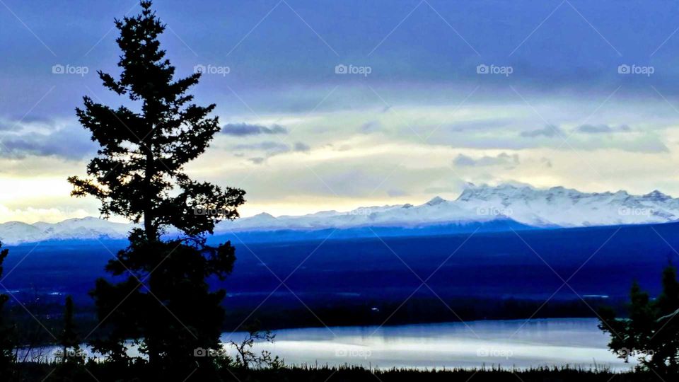 Evening twilight bringing indigo shadows across the mountains and lakes of Alaska.