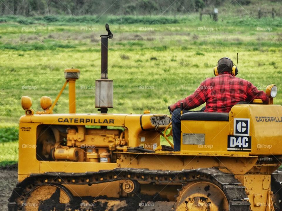 American Farmer Riding Caterpillar Tractor. Farmer On His Tractor
