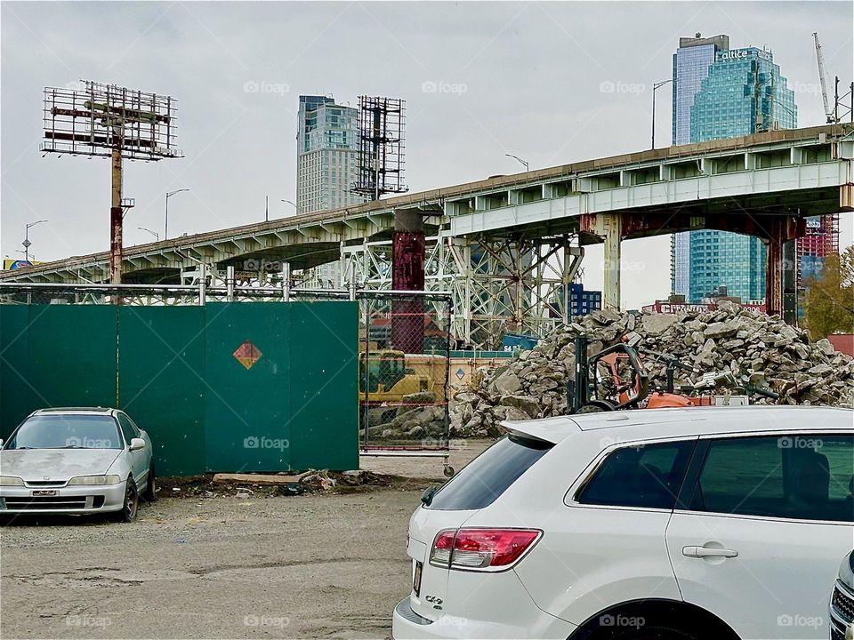 This is the construction site off „Review Ave“ near „Borden Ave“ and „Dutch Kills“ in LIC. Behind it is the ascending slope of the „Bklyn Queens Expressway“ with its characteristic multifaceted metal support structures. 2023. Hypnotic Productions