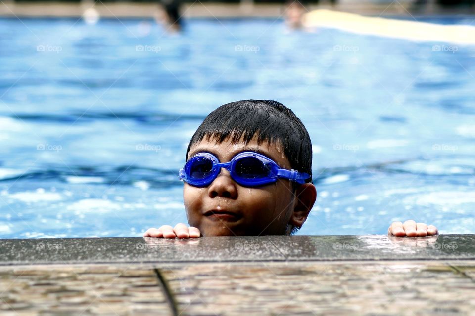 young boy with goggles in a swimming pool